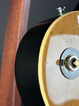 Close-up of a guitar's soundhole with a brand name on the pickguard.