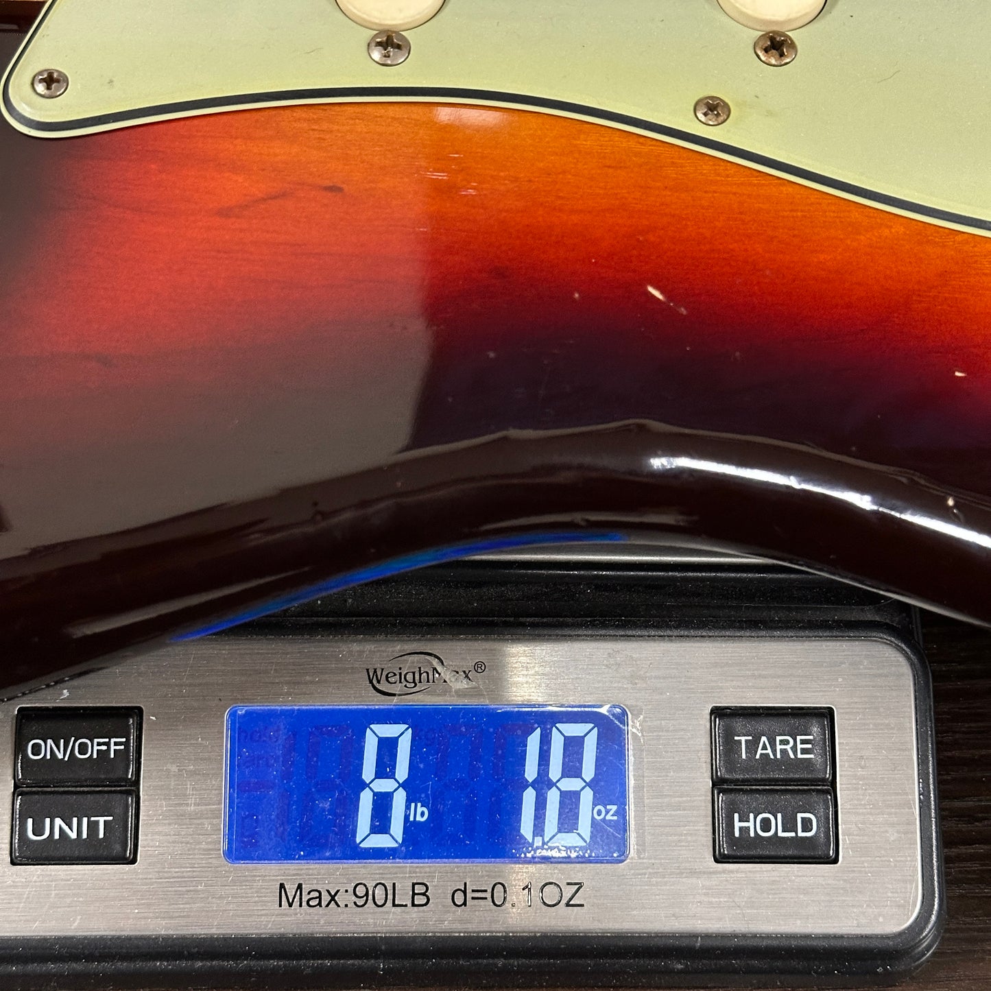 Digital scale displaying weight on a guitar