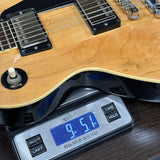 Electric guitar on a digital scale displaying weight