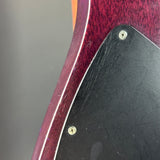 Close-up of a guitar's body with a visible scratch on the black pickguard.