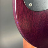 Close-up of a guitar's wood grain finish with a metallic screw.