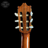 Close-up of a guitar headstock with tuning pegs on a black background, featuring the Tone Shop logo.