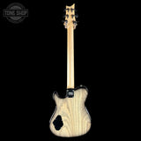 A natural wood electric guitar shown from the back against a solid black background, featuring a light-colored wood body with prominent grain, a black pickguard, and a Tune Shop watermark in the upper left corner.