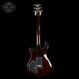 Glossy brown electric guitar on a black background with 'Tone Shop' logo.