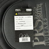 A close-up of a black PRS guitar headstock or instrument cover with a white and black product tag attached. The tag shows PRS branding and handwritten details including model NF53 and serial number 0427949.