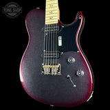 A double-cutaway electric guitar with a dark purple and red glitter finish, a black pickguard, and a maple neck, shown against a black background with a Tone Shop watermark in the top left corner.