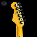 Close-up of a yellow guitar neck with tuning pegs on a black background, featuring 'Tone Shop' branding.