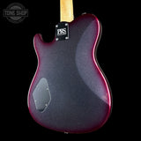 The back of aPRS Guitar electric guitar with a dark purple and black glitter finish and a red edge glaze, shown against a black background.