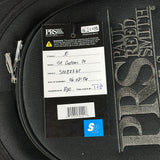 A close-up of a black PRS guitar bag or case with a large embossed PRS logo, showing a product tag for a 'St Custom 24' model. The tag includes a white paper insert with handwritten details and a blue 'S2' sticker at the bottom.