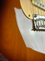 Close-up of a guitar's neck and fretboard with a blurred background