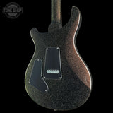 The back of an electric guitar with a black glitter finish, featuring a black pickguard and a silver control plate, shown against a solid black background with a Tone Shop watermark in the top left corner.