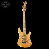 Electric guitar with a wooden finish on a black background, featuring the Tone Shop logo.