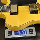 Yellow electric guitar on a digital scale displaying weight