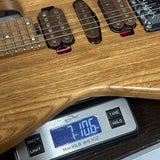Digital scale displaying weight of a wooden guitar neck
