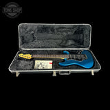 Blue electric guitar in a hard-shell case with 'Tone Shop' logo.