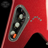 Close-up of a red glitter electric guitar body showing the control cavity with three silver potentiometers, multicolored wiring, and a small orange switch, with mounting holes on the side.