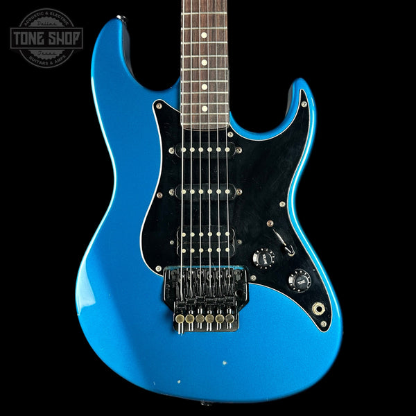 Blue electric guitar on a black background with 'Tone Shop' logo.