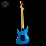 Blue electric guitar with a black pickguard on a white background