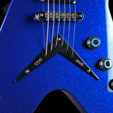 Close-up of a blue electric guitar body with a black chevron-shaped pickguard, silver strings, and blue-tinted control knobs on a dark background.