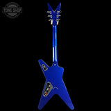 A blue electric guitar shown from the back against a solid black background, featuring a distinctive angular body and headstock with chrome hardware.