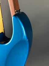 Close-up of a blue electric guitar neck against a gray background