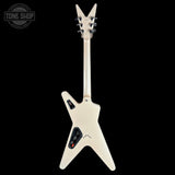 The back view of an electric guitar with a cream-colored body and headstock, featuring a distinctive V-shaped silhouette, black control panels, and silver tuning keys, set against a solid black background.