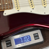 Used 2015 Fender American Standard RW Mystic Red on scale displaying weight.