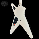 The back of a white electric guitar with a distinctive angular body shape, black control panel, and silver screws, shown against a solid black background with a Tone Shop watermark in the top left corner.