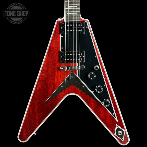 A red and black electric guitar with a V-shaped body, shown from the front against a solid black background. A Tone Shop watermark is visible in the top-left corner.