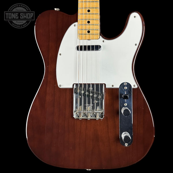 Electric guitar with a wooden body and white pickguard on a black background, featuring the Tone Shop logo.