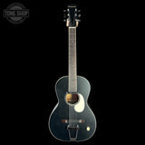 A dark blue acoustic guitar with a glossy finish, featuring a white pickguard and a gold-toned sound hole rosette, shown against a solid black background.