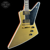 Electric guitar with gold and black design on a black background, featuring 'Tone Shop' logo.