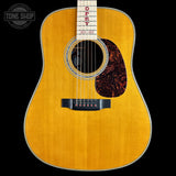 An acoustic guitar with a natural wood finish, featuring the brand name 'OSCY' and year '1935' printed on the neck, set against a solid black background.