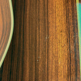 Close-up of a dark brown woodgrain surface with visible grain texture and a small portion of a patterned object at the right edge.
