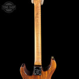 Wooden guitar neck with a visible brand logo on a black background