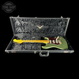 Green electric guitar in a black case with 'Tone Shop' logo.