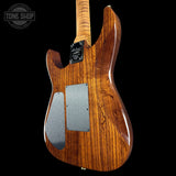 Wooden electric guitar body with brand logo on a black background