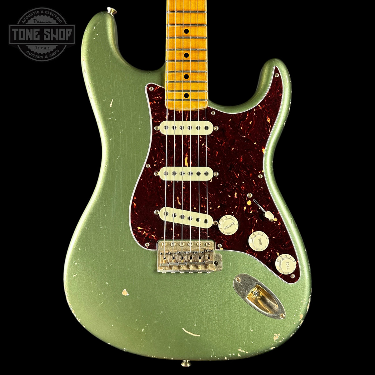 Green electric guitar with a worn finish on a black background, featuring the Tone Shop logo.