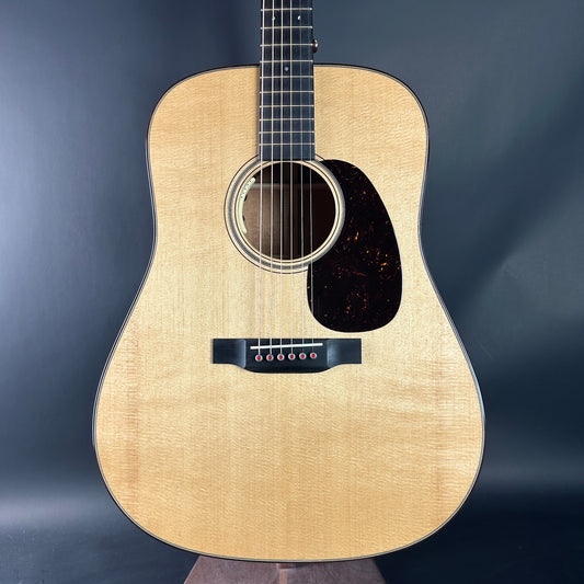 Acoustic guitar with a natural wood finish on a dark background