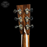Close-up of a guitar headstock with tuning pegs on a black background, featuring 'Tone Shop' branding.
