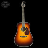 Acoustic guitar with a sunburst finish on a black background, featuring the Tone Shop logo.