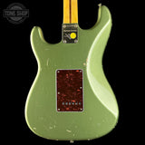 Green electric guitar with a visible brand logo on a black background