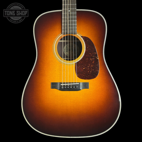 Acoustic guitar with a sunburst finish on a black background, featuring the Tone Shop logo.