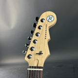 Guitar headstock with brand logo on a dark background