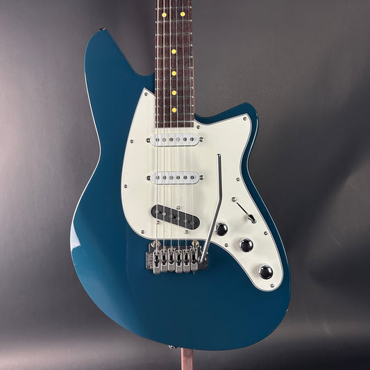 Blue electric guitar on a gray background