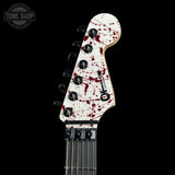 Guitar headstock with red splatter design on a black background, featuring 'Tone Shop' logo.