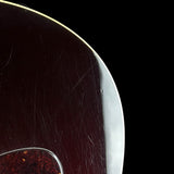 Close-up of a glossy dark reddish-brown guitar body edge with visible scratches on the finish, set against a solid black background.