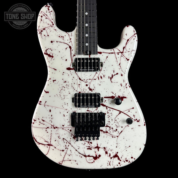 Guitar with red splatter design on a black background, featuring the Tone Shop logo.