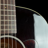 Close-up of an acoustic guitar showing the dark glossy body, soundhole rosette, strings, and part of the fretboard against a black background.