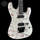 White electric guitar with red splatter design on a black background, featuring the Tone Shop logo.